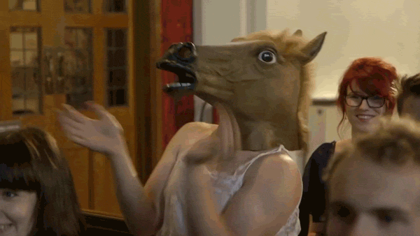мужчина аплодирует в маске лошади